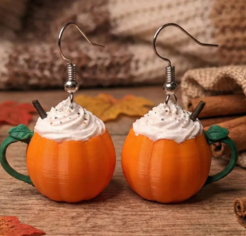 3D printed pumpkin spice latte earrings on wooden surface fall setting