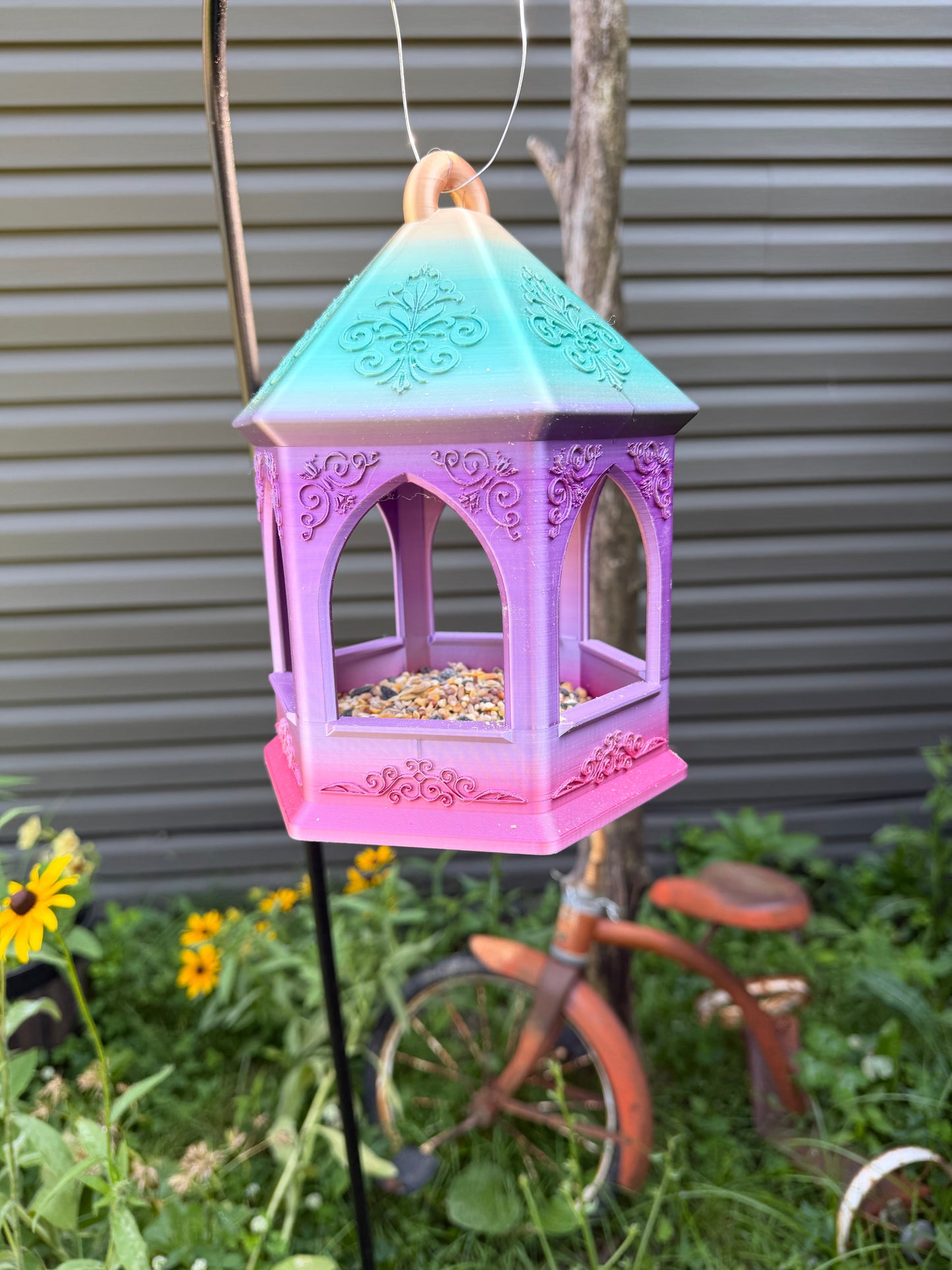 Close-up of embossed scroll detail on bird feeder base