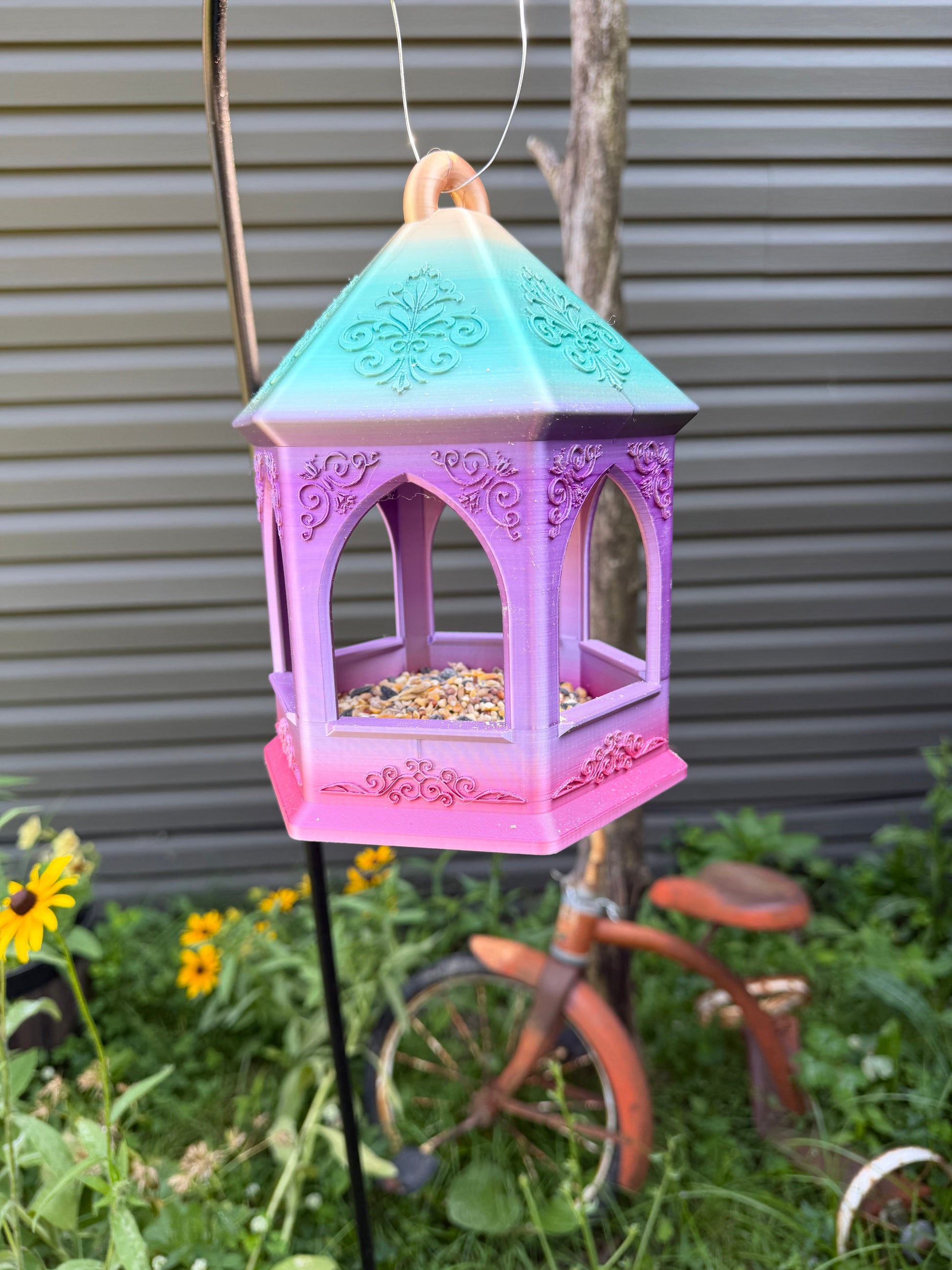 Close-up of embossed scroll detail on bird feeder base