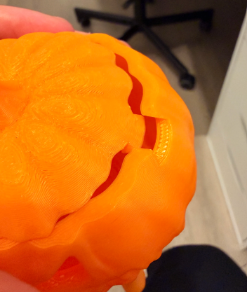 Close-up of the removable lid on the melting jack-o-lantern pumpkin